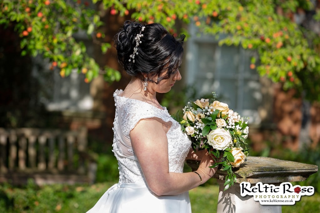 Bride looks down at her flowers at Tullie House Museum and Art Gallery